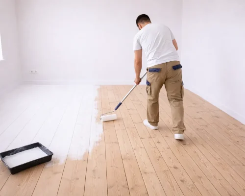 person i gang med maling af gulv